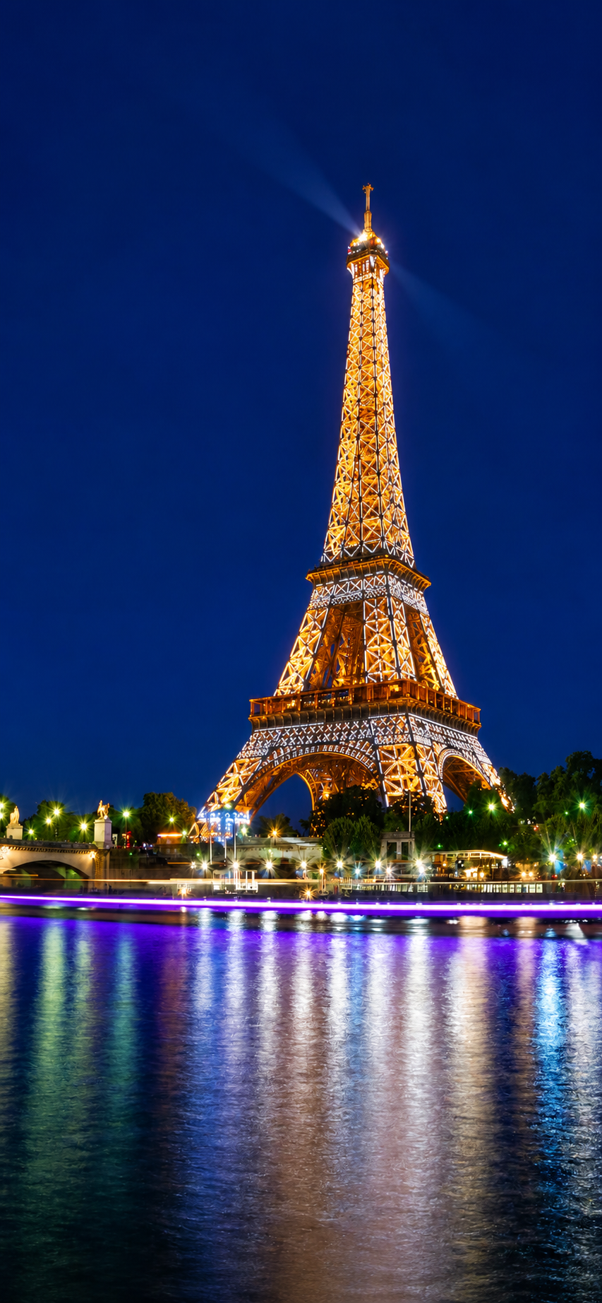 The Eiffel Tower illuminated at night reflected in the Seine, Paris, France
